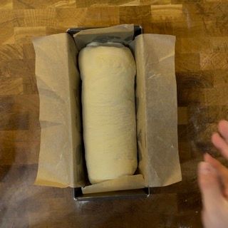 Una pagnotta di pane in uno stampo da plumcake avvolta in carta oleata