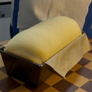 Una pagnotta di pane in una padella su un tavolo a scacchi