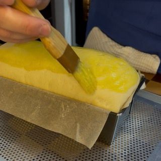 Una persona sta spazzolando una pagnotta di pane con una spazzola