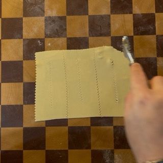 Dettaglio dei due tagli centrali sulle chiacchiere di carnevale prima della frittura.