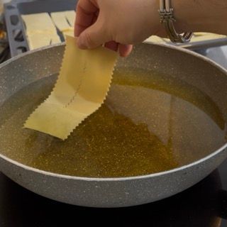 Immersione delle chiacchiere di carnevale bollose nell'olio di semi di arachide a 170°.