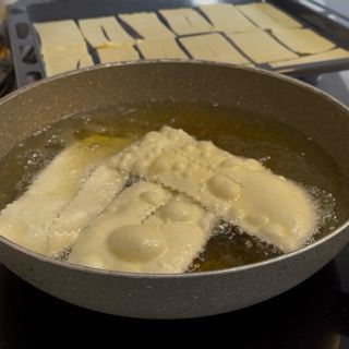 Formazione immediata delle bolle sulla superficie delle frappe carnevale in cottura.