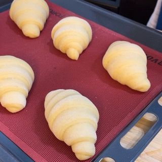 I croissant sono appoggiati su un tappetino rosso con la scritta 