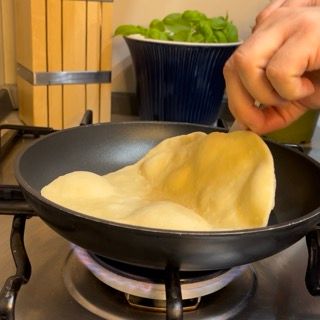 Una persona sta cucinando del cibo in una padella su un fornello
