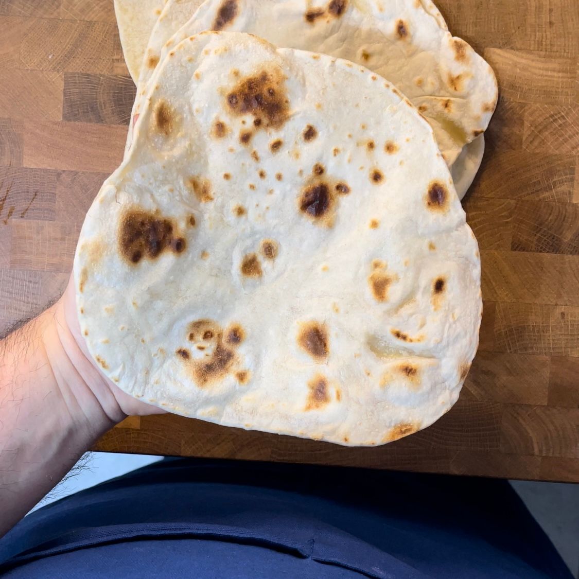 Una persona tiene in mano un pezzo di tortilla.