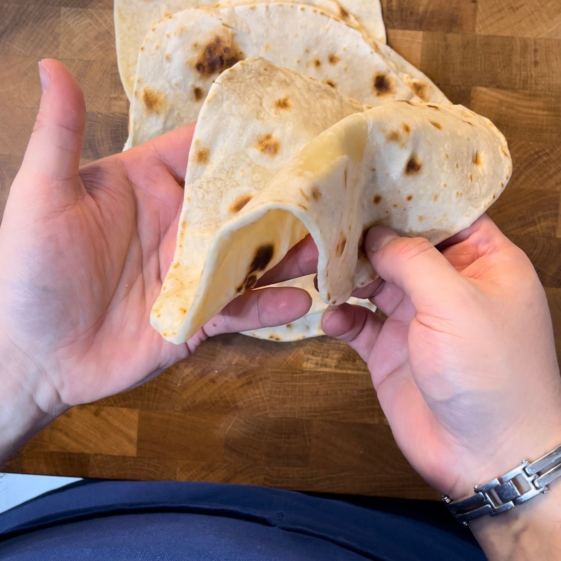 Una persona tiene in mano un pezzo di tortilla.