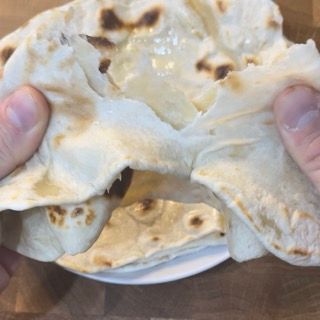 Una persona tiene in mano un pezzo di tortilla.