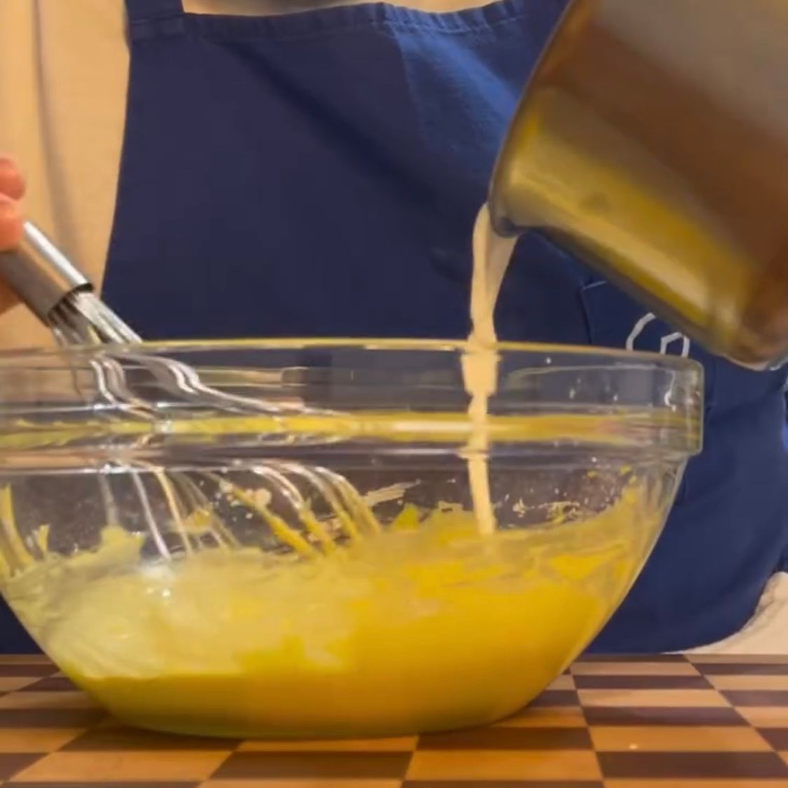 Latte bollente versato sul composto di tuorli per iniziare la pastorizzazione