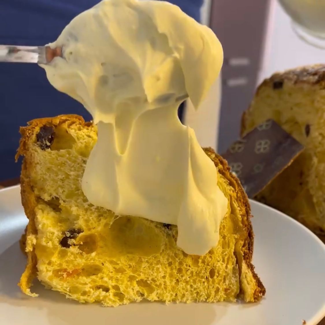 Crema al mascarpone servita generosamente sopra una fetta di panettone.