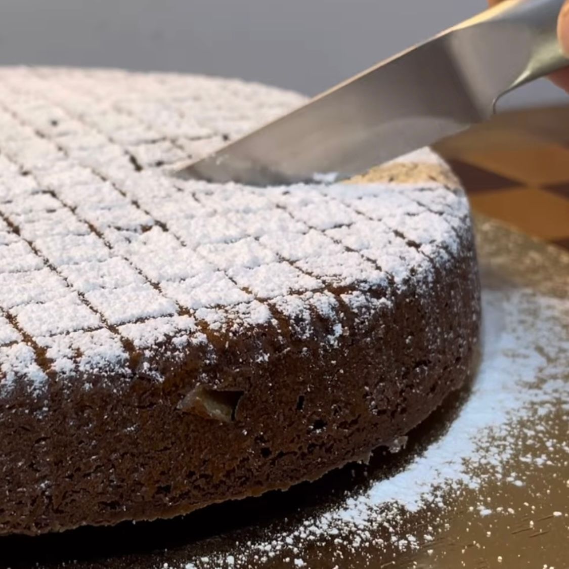 Torta Caprese originale appena sfornata, con la sua tipica crosticina crepata e una spolverata di zucchero a velo.