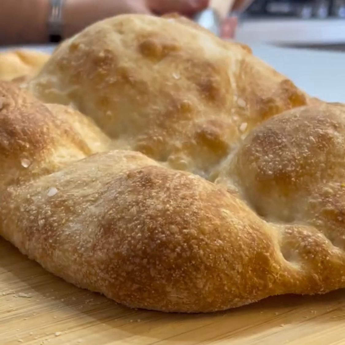 Estrazione della pizza dorata con alveolatura visibile sui bordi.