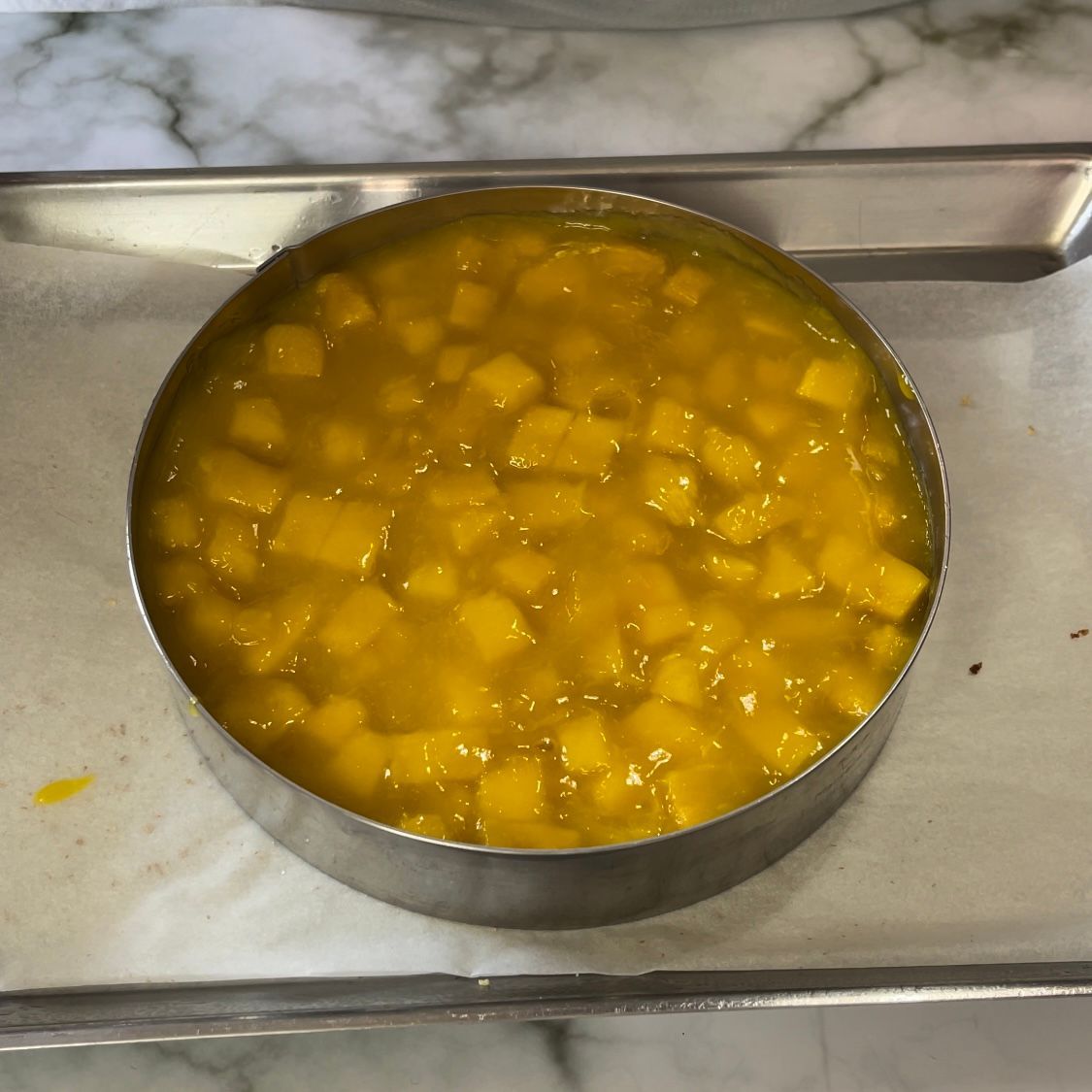 Una ciotola di metallo piena di un liquido giallo su un vassoio