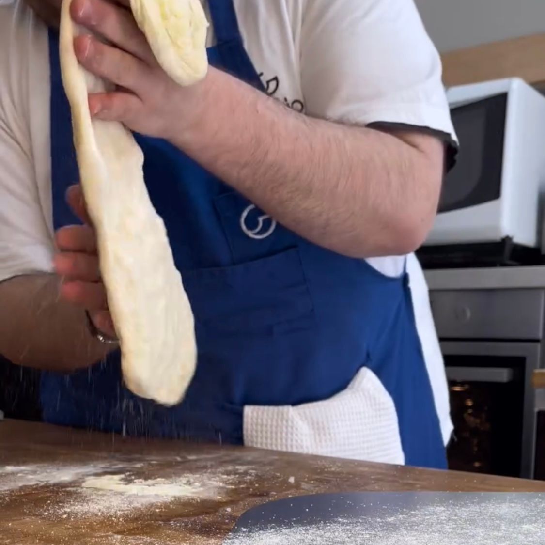 Rimozione della semola in eccesso dalla base della pizza bianca.
