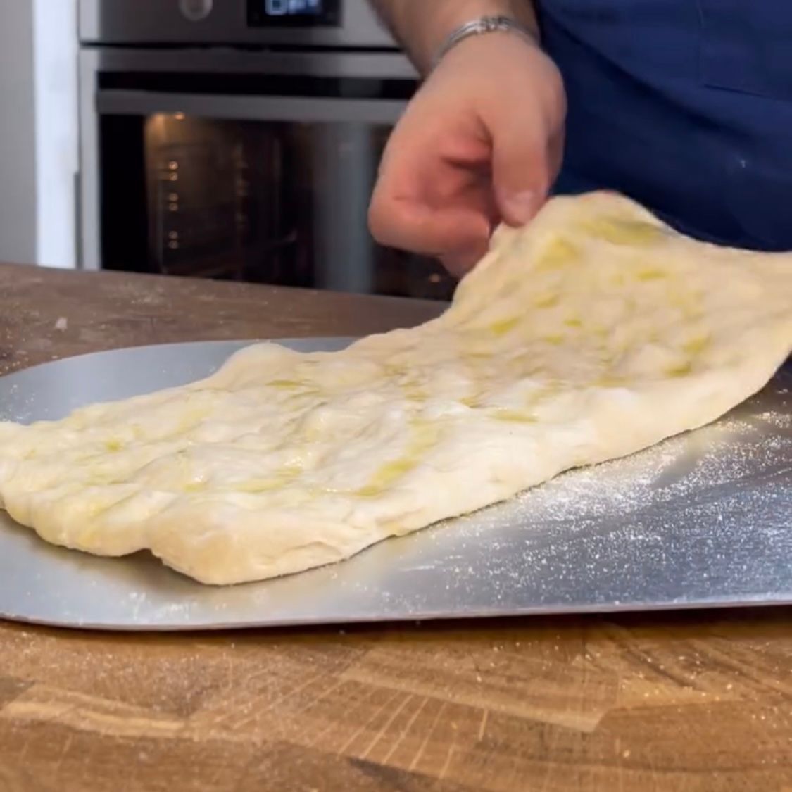 Pizza pronta per essere infornata sulla pietra refrattaria bollente.