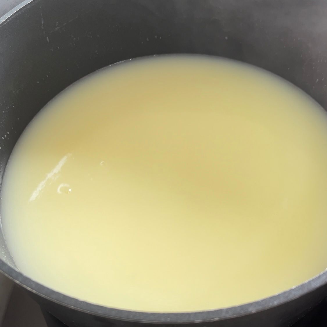 Un primo piano di una pentola piena di un liquido giallo