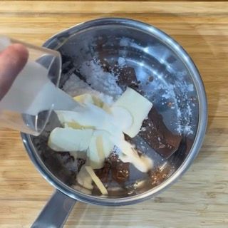 Cioccolato, burro e cacao nel pentolino per il ripieno del babka al cioccolato.