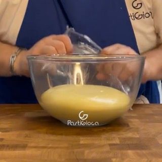 Stesura dell'impasto lievitato con il mattarello sul piano infarinato.