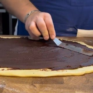 Utilizzo della spatola per livellare il ripieno del babka al cioccolato.
