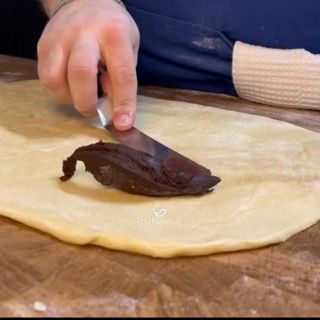 Distribuzione uniforme della crema al cioccolato sulla sfoglia del babka.