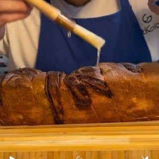 Spennellatura dello sciroppo di zucchero sul babka al cioccolato caldo.