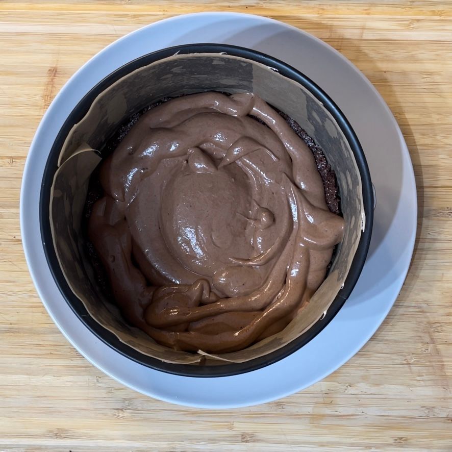 Una ciotola di glassa al cioccolato su un piatto bianco