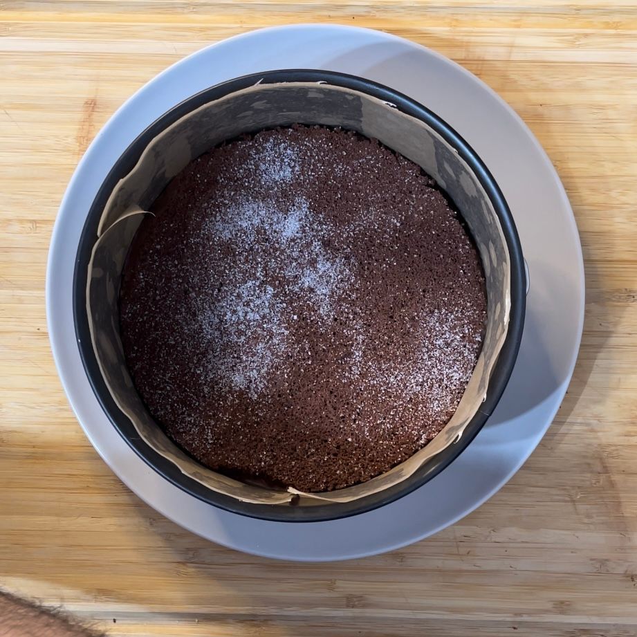 Una torta al cioccolato su un piatto bianco su un tavolo di legno