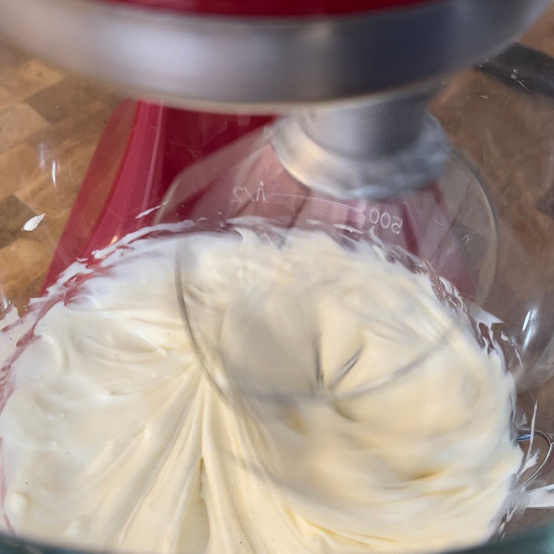 Un primo piano di un frullatore KitchenAid con panna montata al suo interno