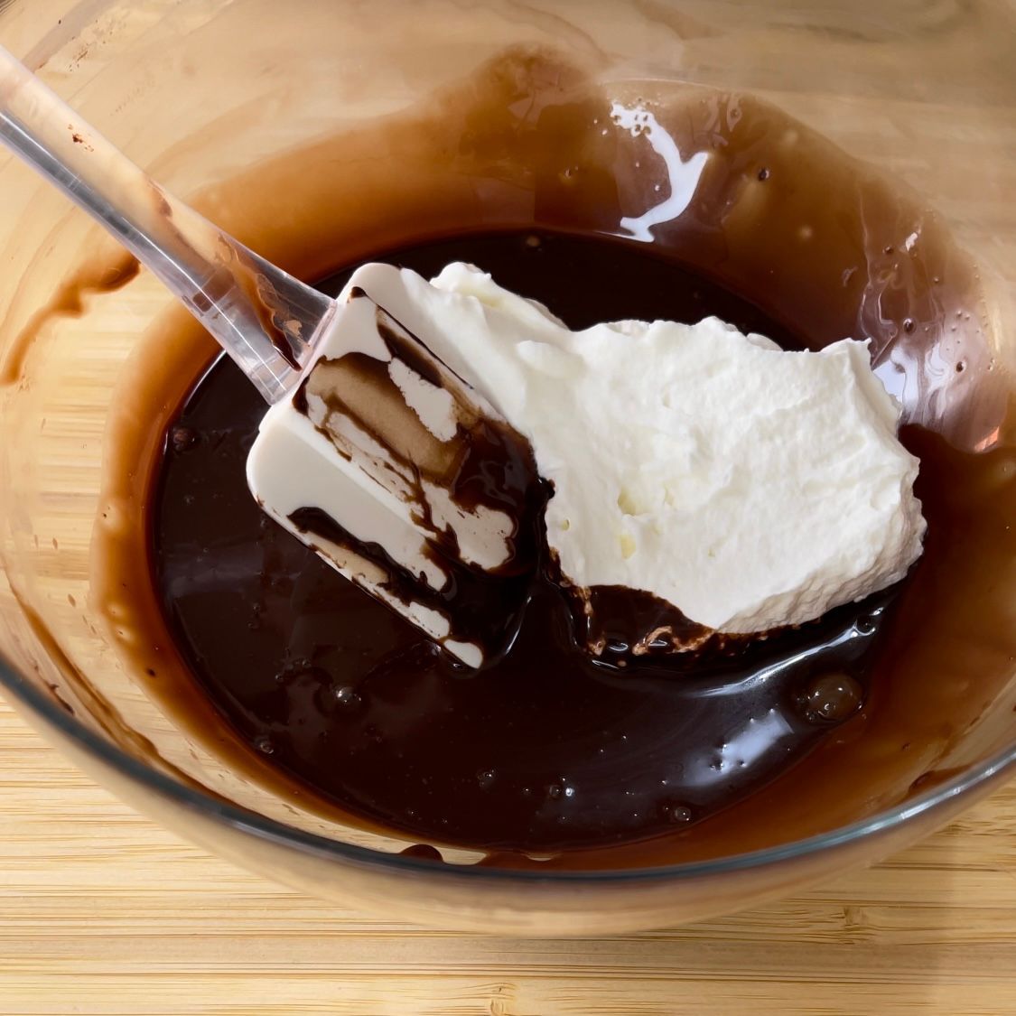 La panna montata viene aggiunta a una ciotola di salsa al cioccolato