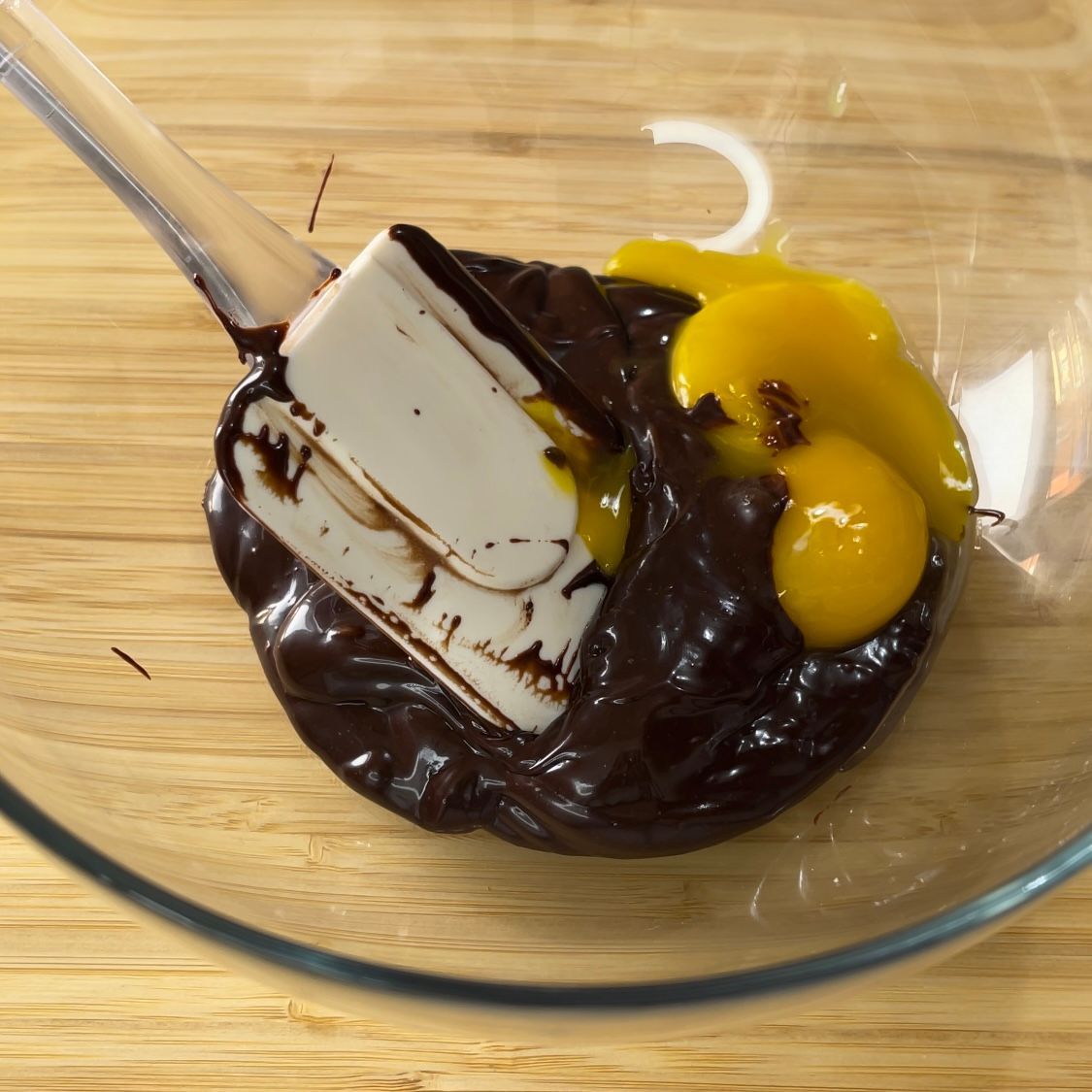 Si sta utilizzando una spatola per mescolare il cioccolato e le uova in una ciotola di vetro