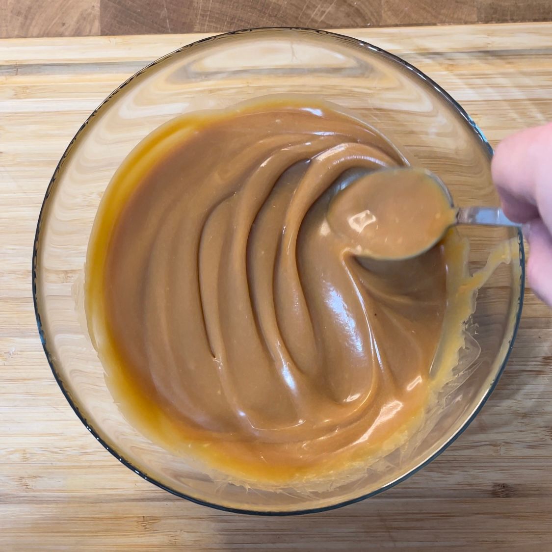 Una ciotola di salsa al caramello con un cucchiaio dentro