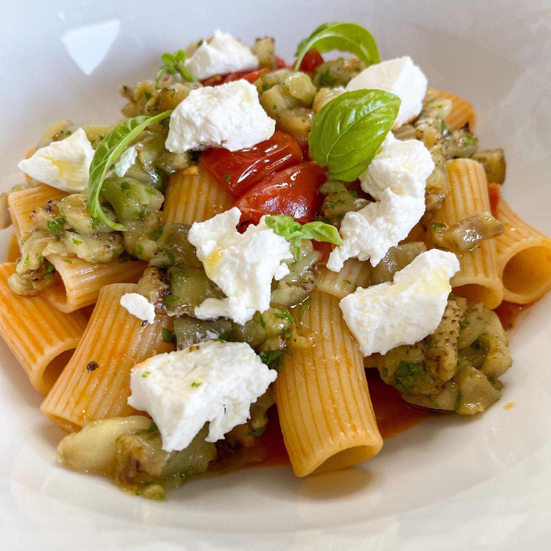 Un primo piano di un piatto di pasta con verdure e formaggio
