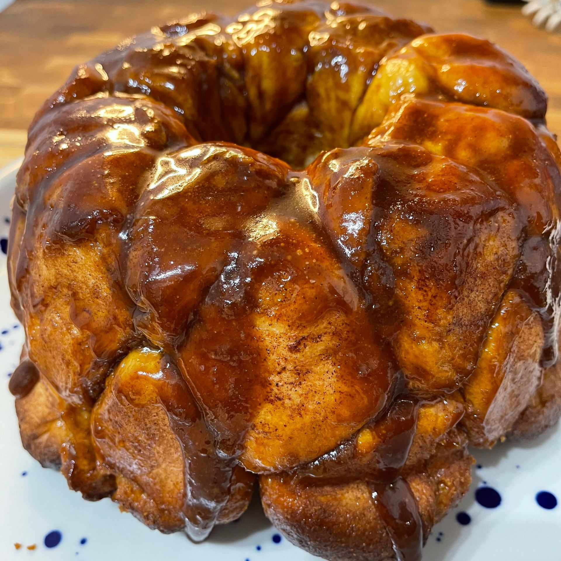 Monkey Bread intero a forma di ciambella, dorato e caramellato, composto da tante palline di brioche unite tra loro.