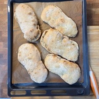 Un vassoio di pane è appoggiato su un tavolo di legno