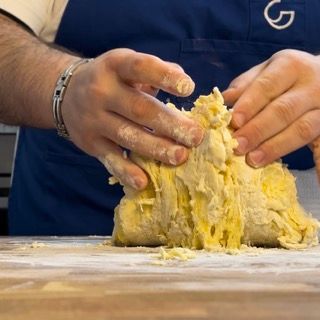 Gancio della planetaria che lavora gli ingredienti fino a ottenere un composto grezzo.