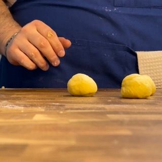 Palmo della mano che arrotonda ogni pezzetto creando una pallina liscia