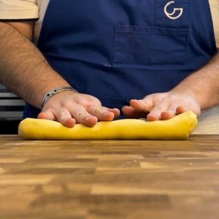 L'impasto arrotolato sul piano di lavoro a formare un lungo filone.