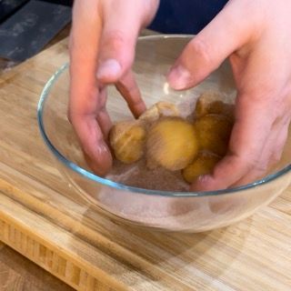 Palline di impasto rotolate nel mix di zucchero e cannella fino a copertura totale