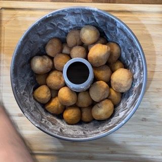 Palline zuccherate disposte in modo disordinato nello stampo a ciambella imburrato