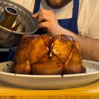 Monkey bread capovolto sul piatto da portata, con il caramello che cola sulle palline