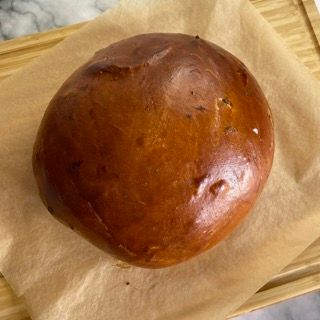 Una pagnotta di pane è appoggiata su un pezzo di carta marrone.