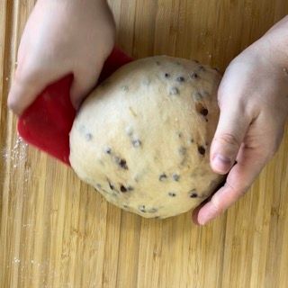 Una persona tiene in mano una palla di pasta su un tagliere