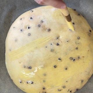 Una persona sta spalmando la glassa gialla su un biscotto.