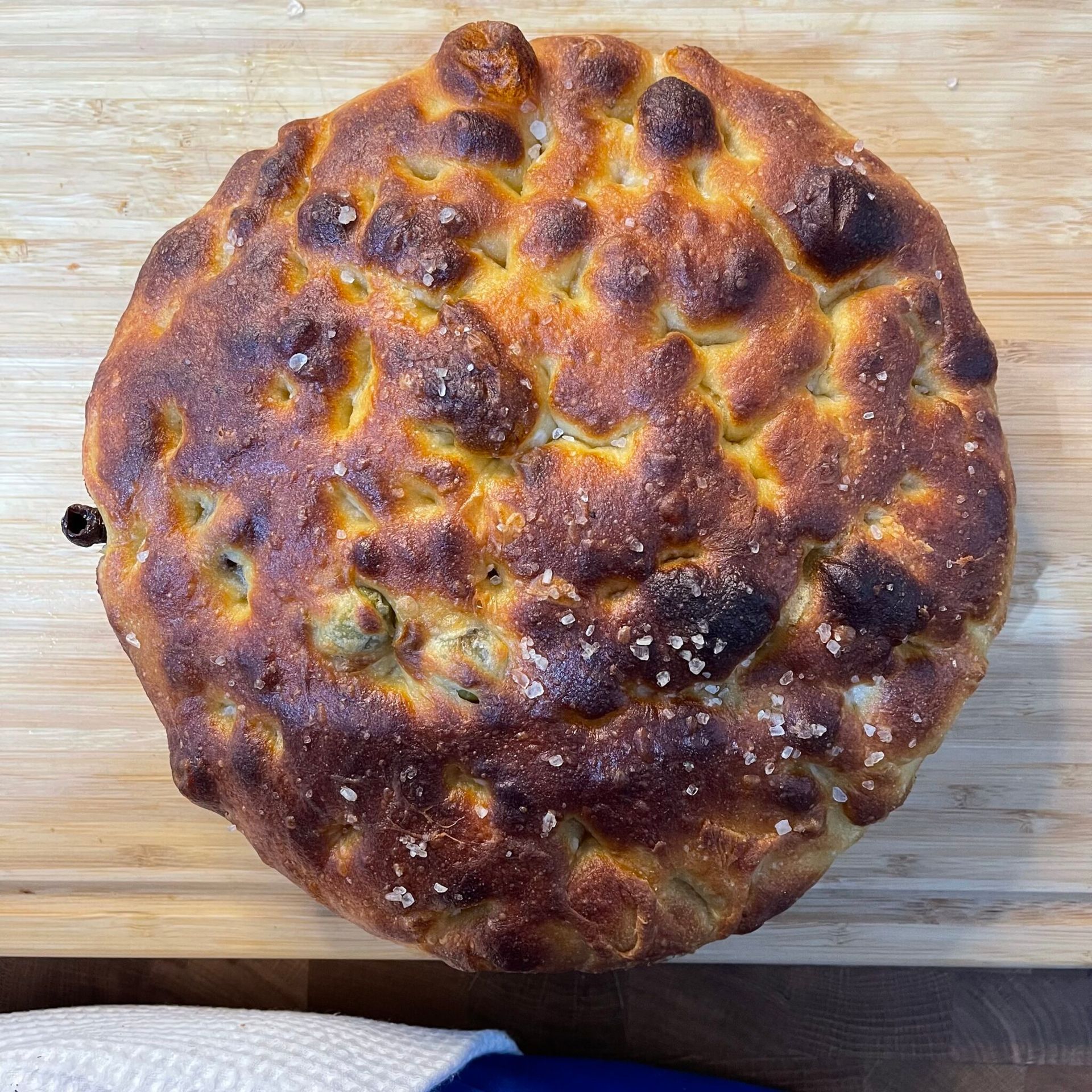 Una pagnotta di pane è appoggiata su un tagliere di legno.