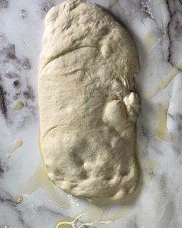Un pezzo di pasta è appoggiato su una superficie di marmo.