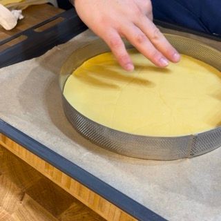 Una persona sta mettendo una torta in una teglia su un tavolo
