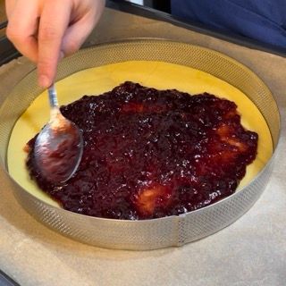 Una persona sta spalmando la marmellata su una torta con un cucchiaio