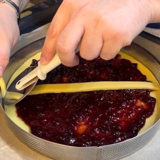 Una persona sta tagliando un pezzo di formaggio in una ciotola di salsa