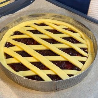 Una torta con una crosta a traliccio è appoggiata su un tavolo