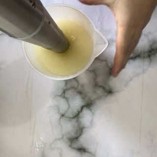 Una persona versa del liquido in un misurino.