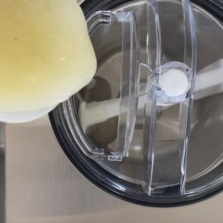 Un primo piano di un frullatore con un coperchio trasparente